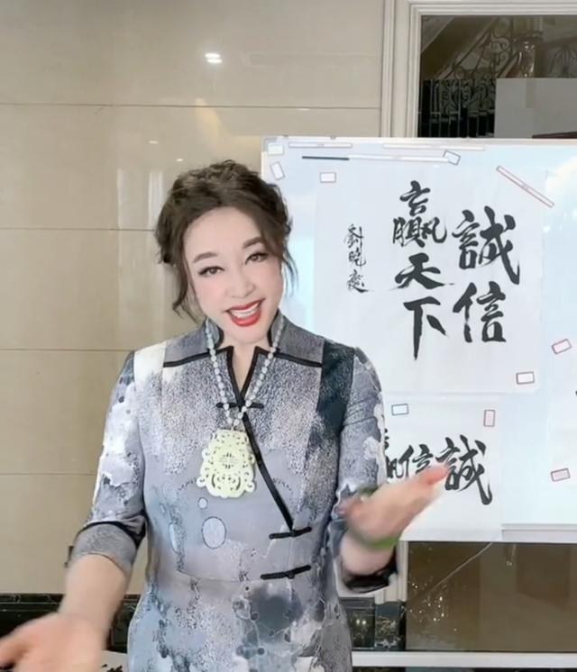 65岁刘晓庆穿旗袍秀身段，戴翡翠手镯超贵气，摆满书法作品办展览